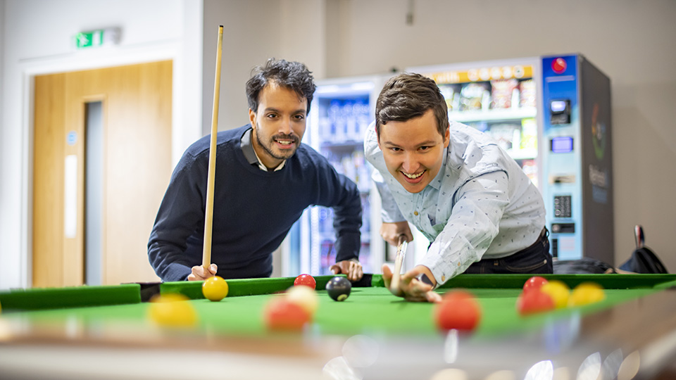 Two RCM students playing pool together Two RCM students playing pool together
